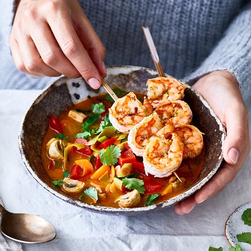 Gemüse-Curry-Suppe mit Garnelenspießen