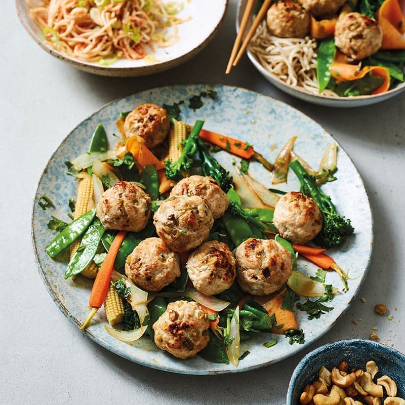 Asiatische Hackbällchen auf buntem Gemüse